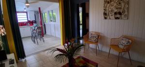 ein Wohnzimmer mit zwei Stühlen und eine Küche in der Unterkunft Les Gites Capra - Papaye in Bouillante