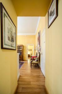 a hallway with yellow walls and wooden floors at Casa Esvael - Historic Rooms in Verona City Center in Verona +38 photos
