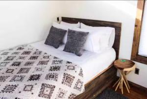 a bed with a black and white blanket and pillows at NEW! Modern Cabin Tiny Home at Cliffside #3 in Orderville
