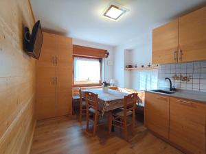 a kitchen with a table and some wooden cabinets at Appartamento panoramico 2 in Candide