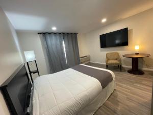 a hotel room with a bed and a flat screen tv at St Croix Suites - St Croix Falls in Saint Croix Falls
