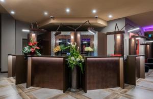 a lobby with a reception counter with flowers at Leonardo Royal Hotel Venice Mestre in Mestre +65 photos