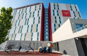a hotel building with sculptures in front of it at Leonardo Royal Hotel Venice Mestre in Mestre