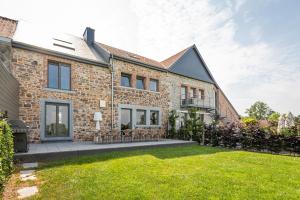 a brick house with a lawn in front of it at Mossefat in Sprimont