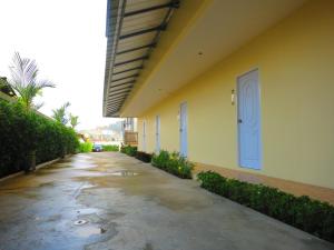 pusty korytarz obok budynku z niebieskimi drzwiami w obiekcie Winrisa Place w mieście Nai Yang Beach