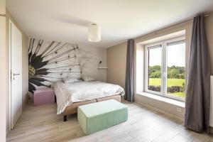 a bedroom with a bed and a large window at Mossefat in Sprimont