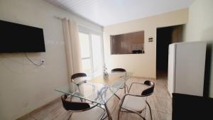 a dining room with a glass table and chairs at Casa Miríades in Hortolândia