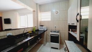 a small kitchen with a sink and a stove at Casa Miríades in Hortolândia +10 photos