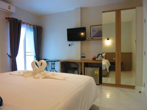 Habitación de hotel con cama con toalla en forma de corazón en Winrisa Place, en Nai Yang Beach