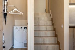 a staircase with a washing machine in a bathroom at Beachfront Design LUX Studio Apartment in Estepona