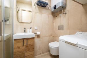 a bathroom with a sink and a toilet and a mirror at Beachfront Design LUX Studio Apartment in Estepona +5 photos