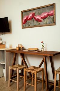 a wooden table with four chairs and a painting of red flowers at I Trulli del Tupparello in Fasano