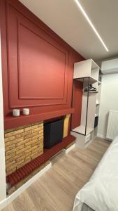 a room with a fireplace with a red wall at By The River Stay in Florina +24 photos