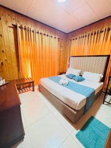 una camera da letto con un grande letto e pareti in legno di Single Tree Hotel a Nuwara Eliya