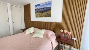 a bedroom with a pink bed with a pink blanket at Cómodo Apto Lago Sochagota in Paipa