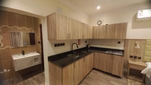 a kitchen with wooden cabinets and a sink at Dar Al-Areed in Medina +62 photos