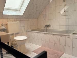 a bathroom with a toilet and a bath tub at Hallighafen in Bredstedt +32 photos