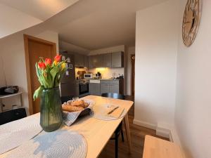 a kitchen with a table with a vase of flowers on it at Hallighafen in Bredstedt