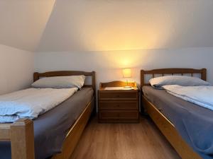 two twin beds in a room with a night stand at Hallighafen in Bredstedt