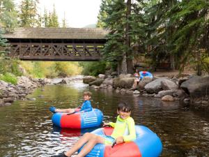 two children are riding on rafts on a river at Vantage Point in Vail