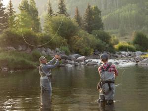 two people standing in the water fishing in a river at Vantage Point in Vail +27 photos