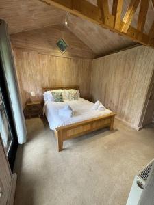a bedroom with a bed in a wooden room at Duxford Lodge, Cholsey in Cholsey