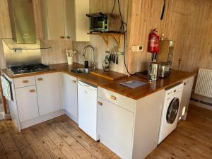 a kitchen with a counter with a sink and a washing machine at Duxford Lodge, Cholsey in Cholsey