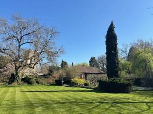 a large yard with a house and trees at Pool House at Mill Cottage in Goring