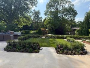 a garden with bushes and flowers in a yard at Pool House at Mill Cottage in Goring