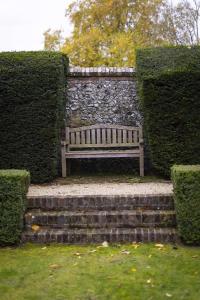 a bench sitting on a set of stairs in front of a stone wall at Pool House at Mill Cottage in Goring +47 photos