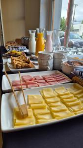 a table with many different types of cheese on plates at Hotel Americano in Perito Moreno