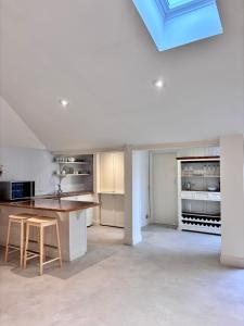 a kitchen with white cabinets and a skylight at The Baydon House Luxury Studio in Marlborough