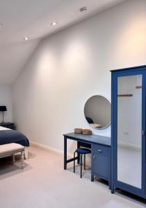 a bedroom with a blue desk and a mirror at The Baydon House Luxury Studio in Marlborough +47 photos