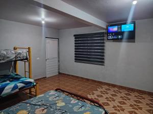 a room with a bed and a tv on the wall at Estancia kv in Coatepec