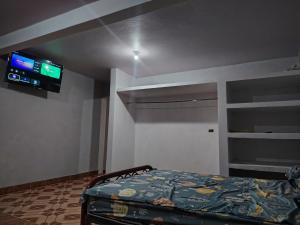 a bedroom with a bed and a tv on the wall at Estancia kv in Coatepec +3 photos