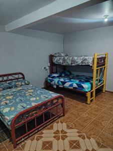 a bedroom with two bunk beds and a tile floor at Estancia kv in Coatepec