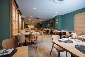 a restaurant with wooden tables and chairs and blue walls at Mondragon Hotela in Mondragón