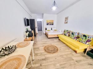 a living room with a yellow couch and a table at Mandala - Studiouri si Apartamente in Eforie Nord +88 photos