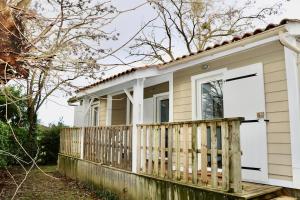 a tiny house with a porch and a door at Le Havre de Paix Chalet in Rivières