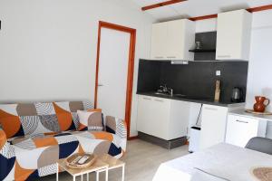 a living room with a couch and a kitchen at Le Havre de Paix Chalet in Rivières