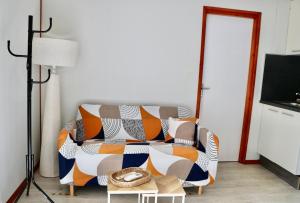 a living room with a couch with a blanket on it at Le Havre de Paix Chalet in Rivières