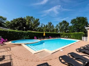 a swimming pool with chaise lounge chairs around it at Le Havre de Paix Chalet in Rivières