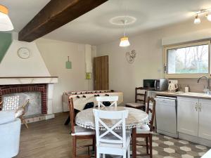 a kitchen with a table and a fireplace at La Maison Agoméa in Saint-Georges-sur-Cher