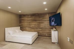 a bedroom with a white bed and a wooden wall at Apart Center in Sumy