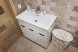 a bathroom with a white sink and a toilet at Apart Center in Sumy