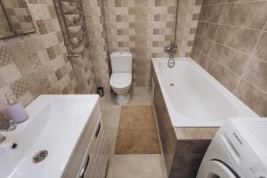 a bathroom with a toilet and a tub and a sink at Apart Center in Sumy +3 photos