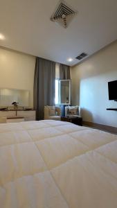 ein Schlafzimmer mit einem großen weißen Bett und ein Wohnzimmer in der Unterkunft Luxury A2 Chalet COMO in Al Khīrān + 50 Fotos
