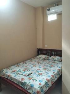 a bedroom with a bed with a floral comforter at PAULIN Surf in Montañita