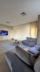 ein Wohnzimmer mit Sofa und Tisch in der Unterkunft Luxury A2 Chalet COMO in Al Khīrān