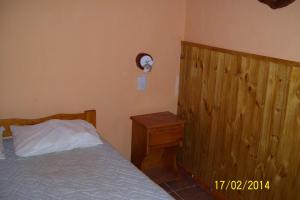a bedroom with a bed and a wooden headboard at Los eucaliptos in Andino
